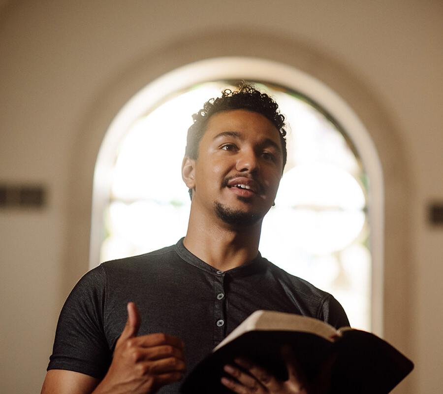 PBA student reads the bible at the front of chapel.